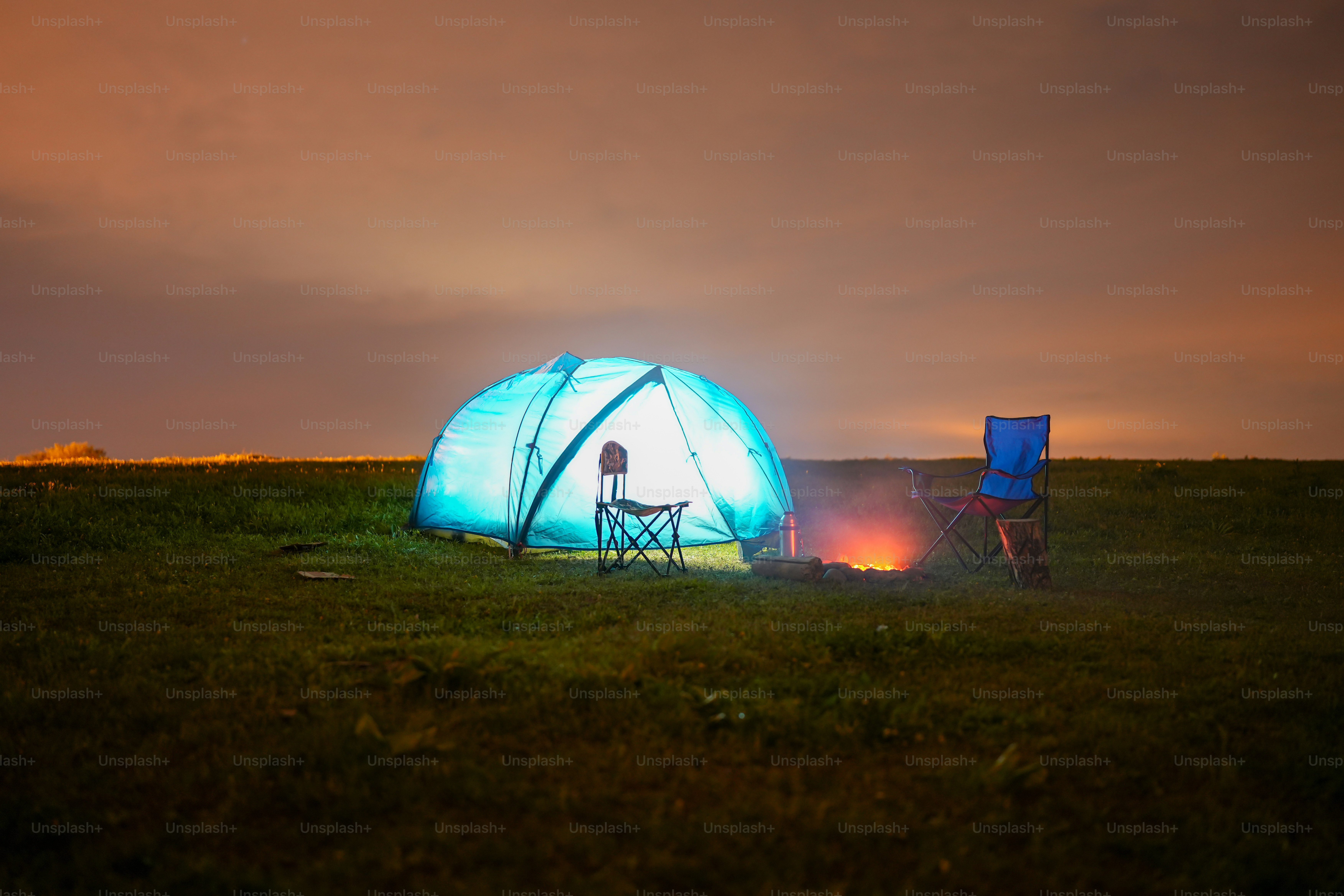 a person sitting in a chair next to a tent