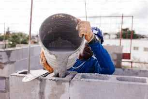 a man in blue overalls and safety gear working on a pipe