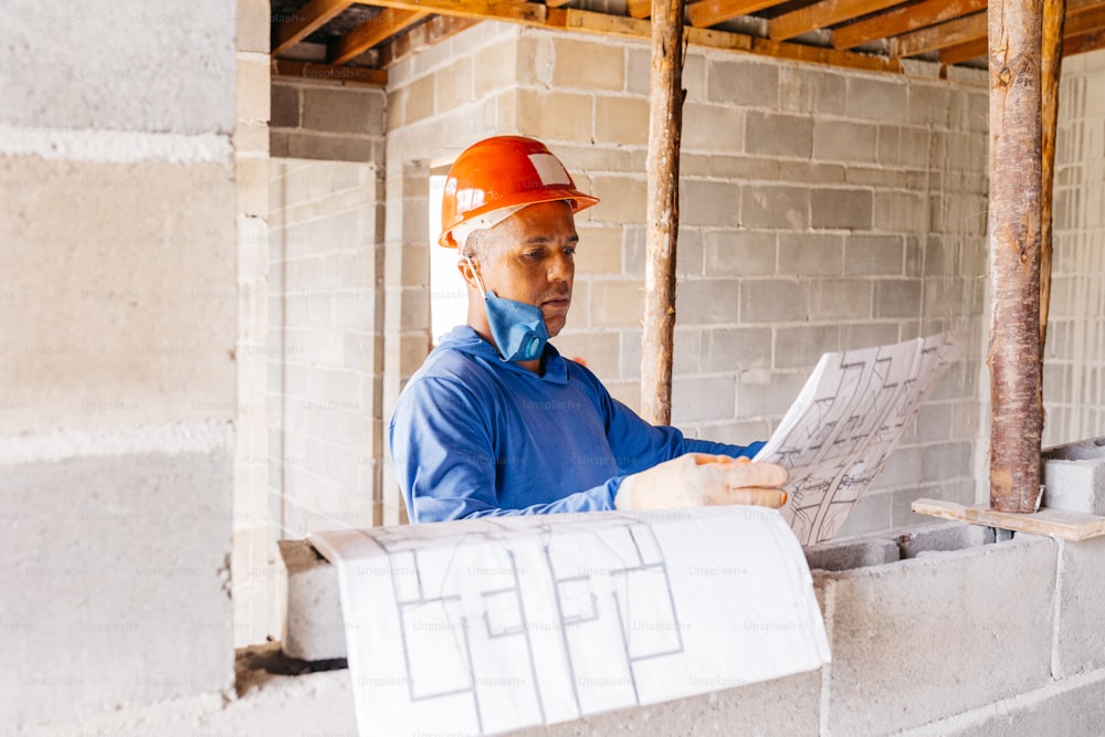 a man in a hard hat is looking at a piece of paper