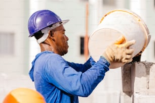 a man wearing a hard hat and holding a drum