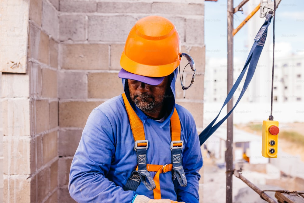 a man wearing a hard hat and orange safety harness
