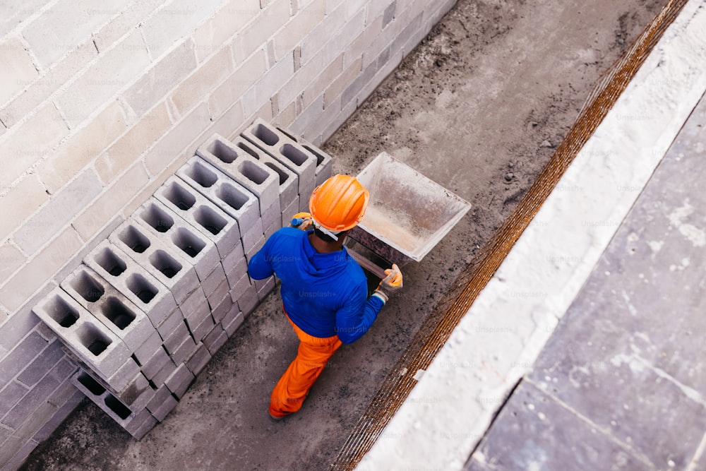 a man in a hard hat and orange pants