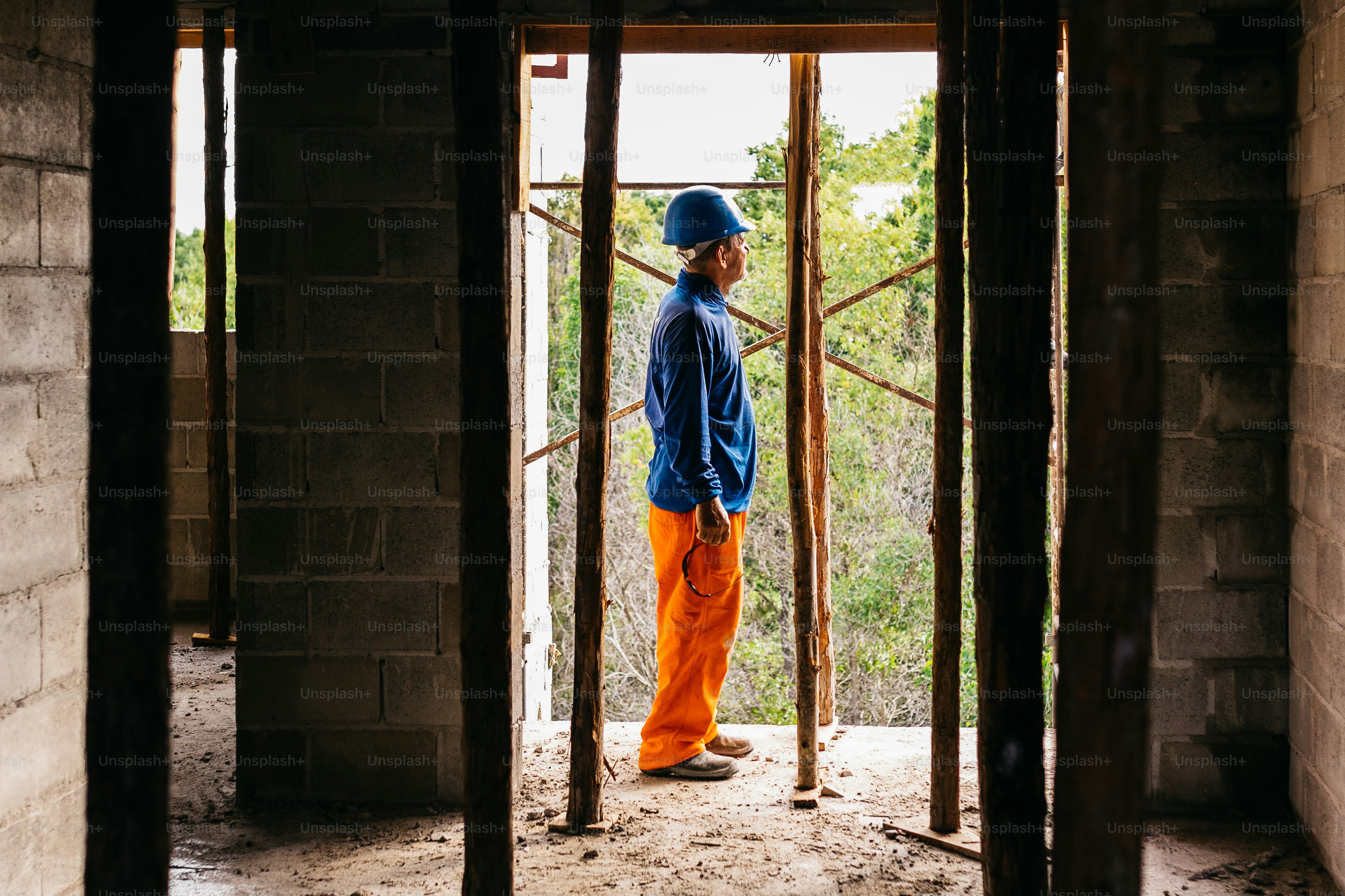 a man in orange pants and a blue jacket standing in a doorway