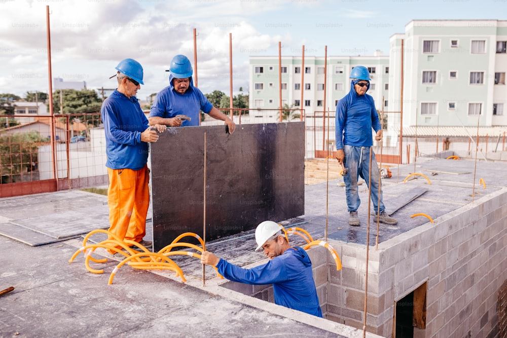 a group of men standing on top of a building under construction