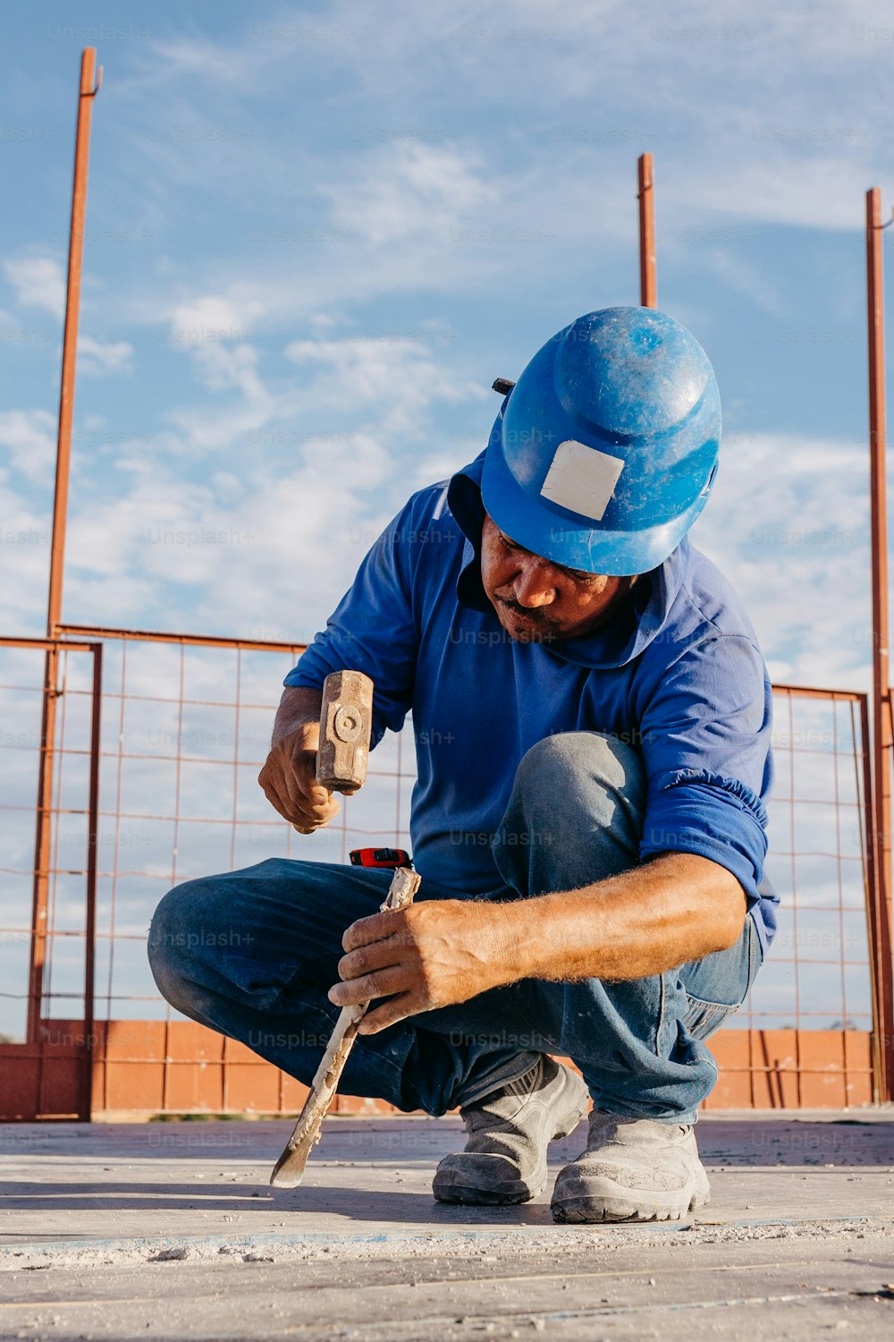 Un hombre con un casco azul está trabajando en un pedazo de madera