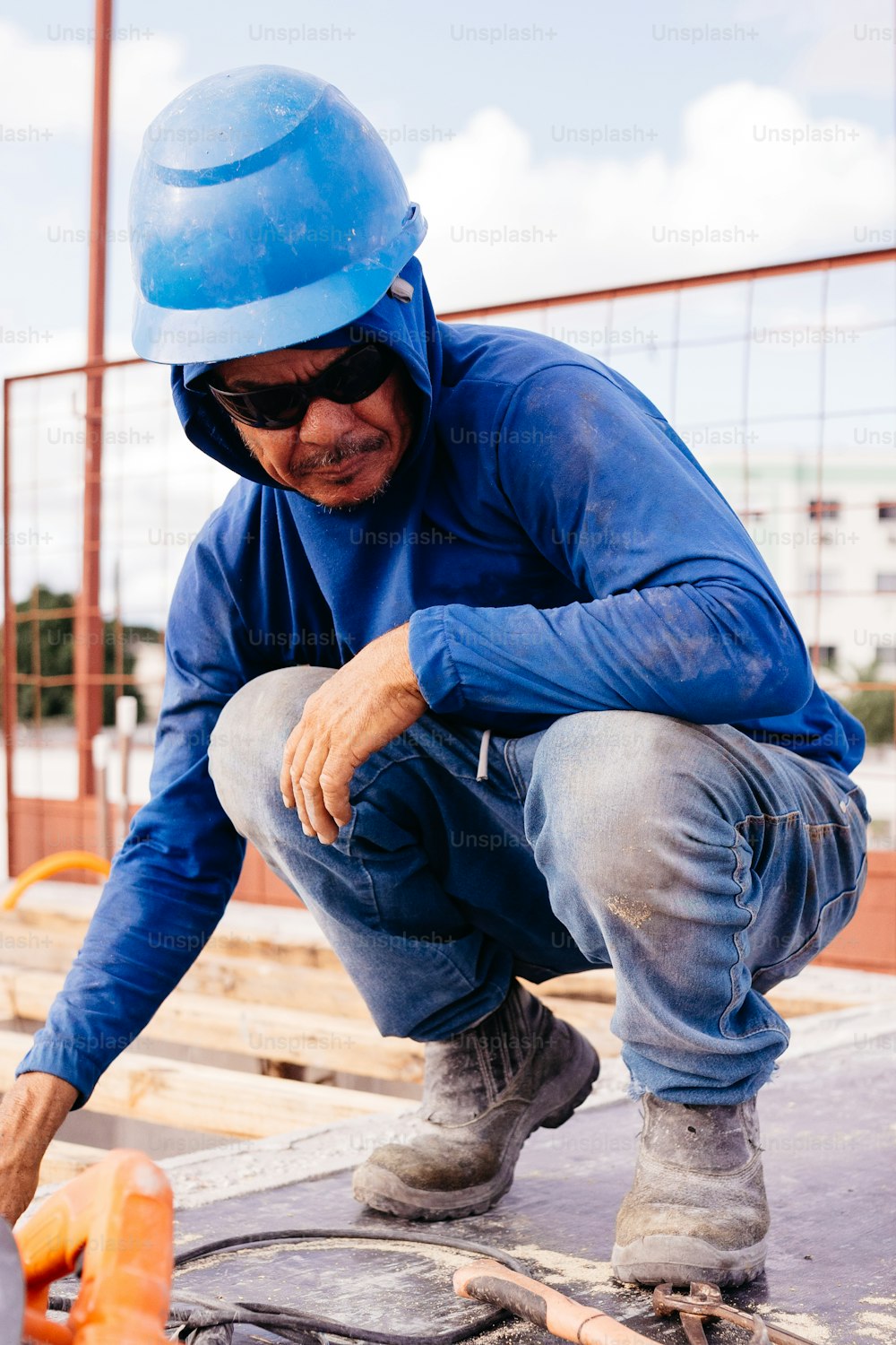 a man wearing a blue helmet is working on a piece of wood