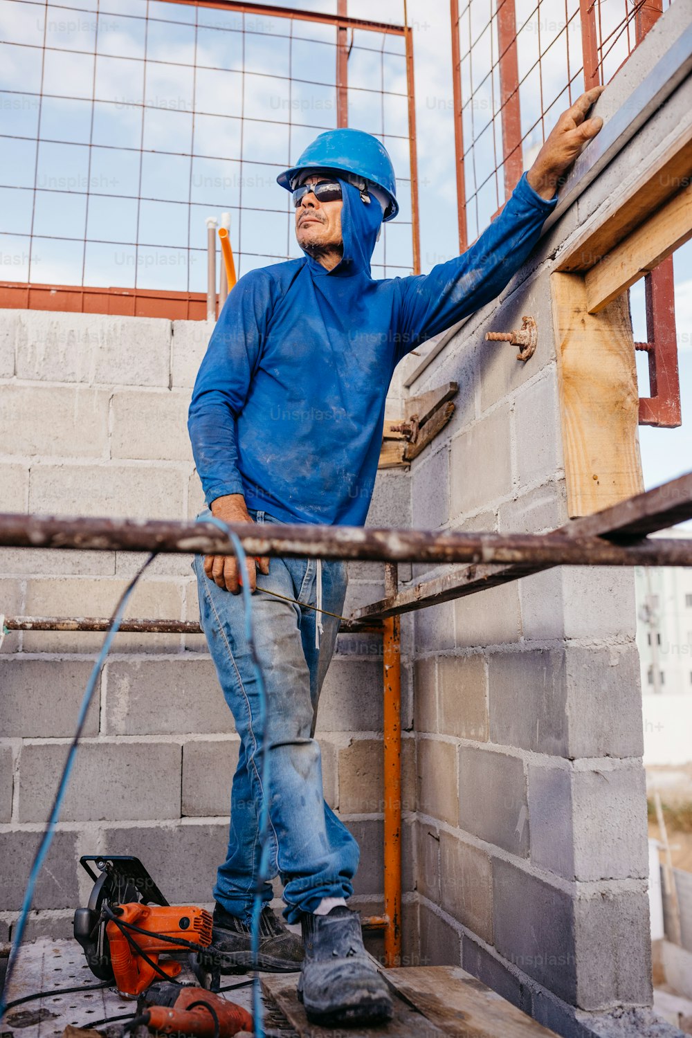 a man in a blue coverall and safety helmet working on a building