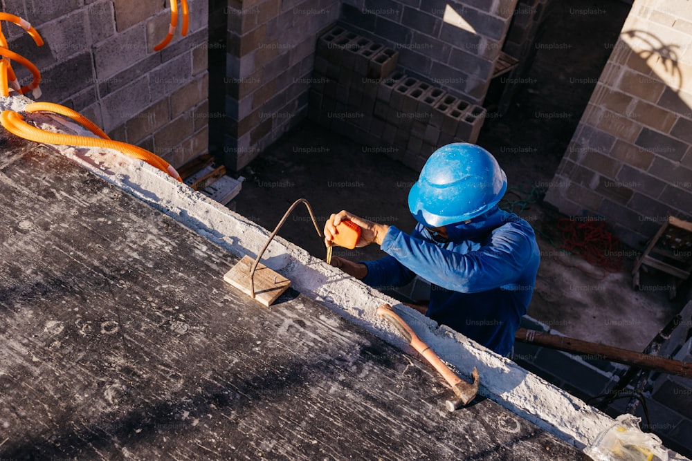 Un hombre con un casco azul trabajando en un techo
