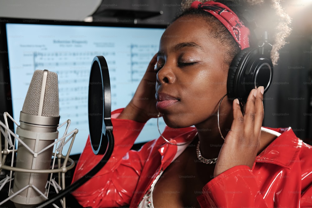 a woman in a red jacket listening to headphones