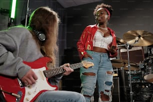a woman in a red jacket playing a guitar