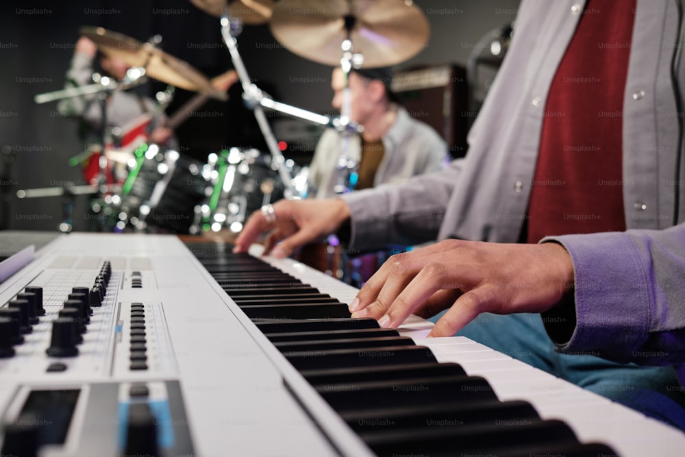 a man playing a keyboard in front of a drum set