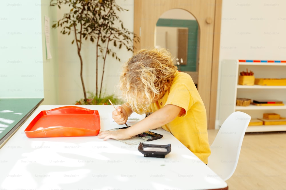 a child writing on a piece of paper at a table