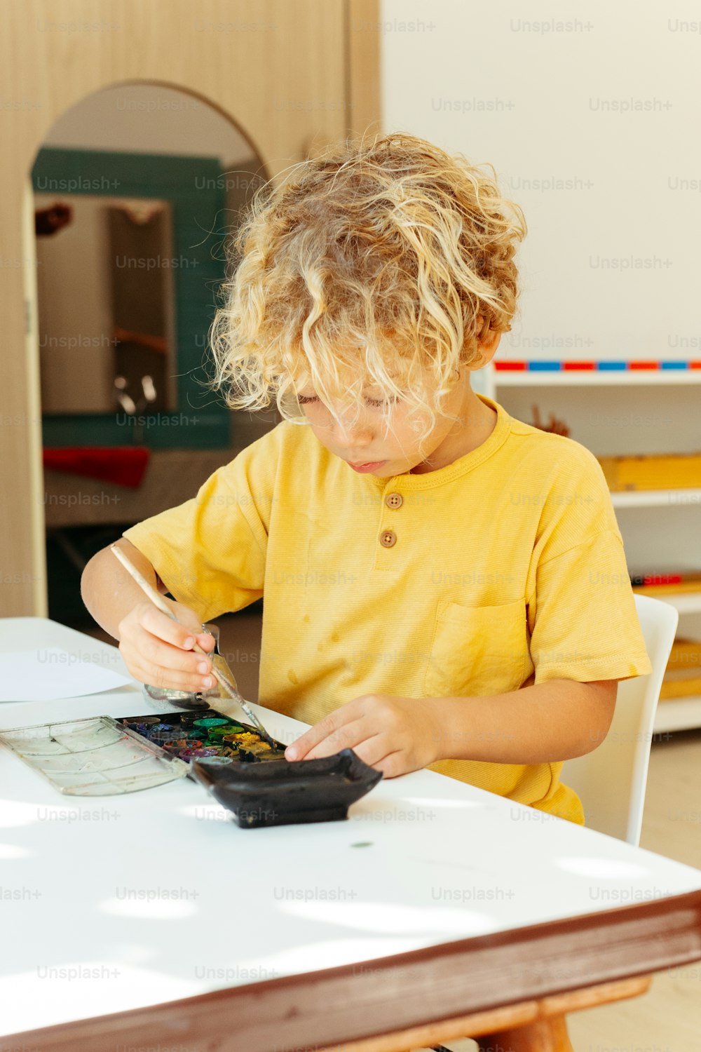 a little boy sitting at a table with a calculator