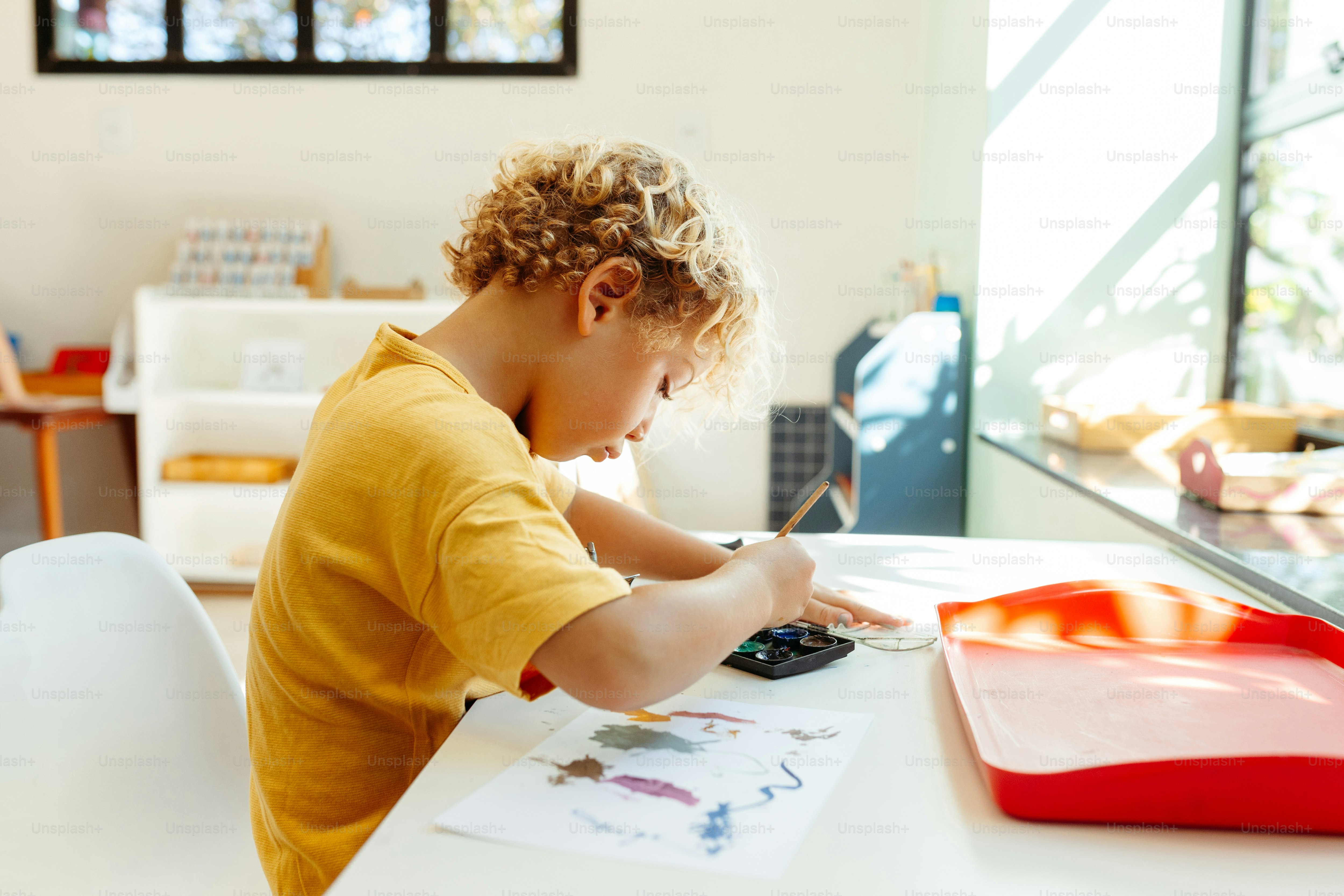 a little boy sitting at a table with a calculator