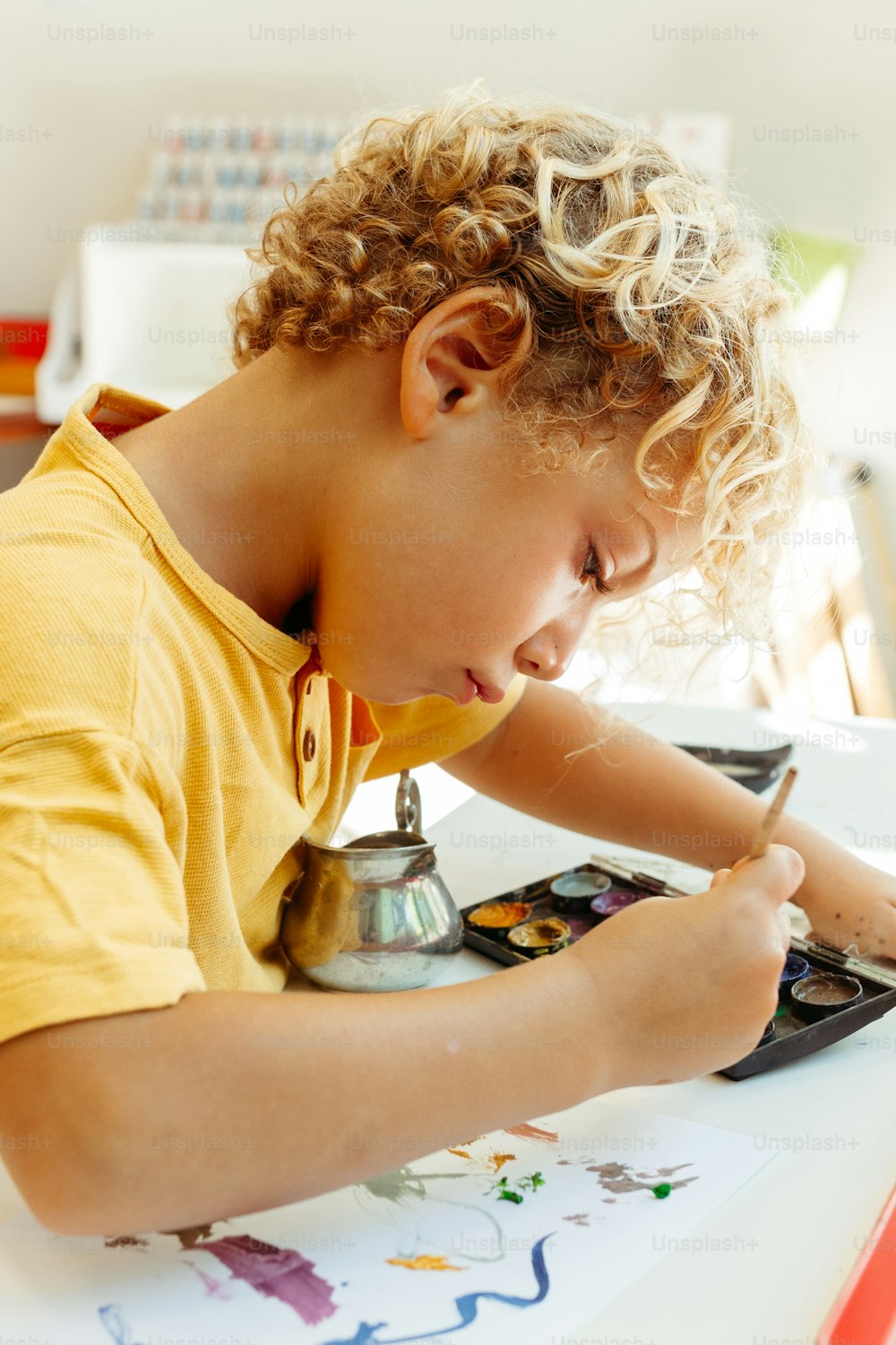 Un jeune garçon dessine sur un morceau de papier