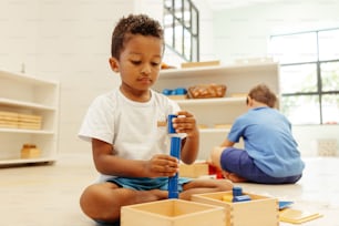 a young boy playing with a wooden toy