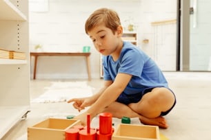 Un giovane ragazzo che gioca con i giocattoli sul pavimento