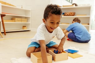 a young boy playing with wooden blocks on the floor