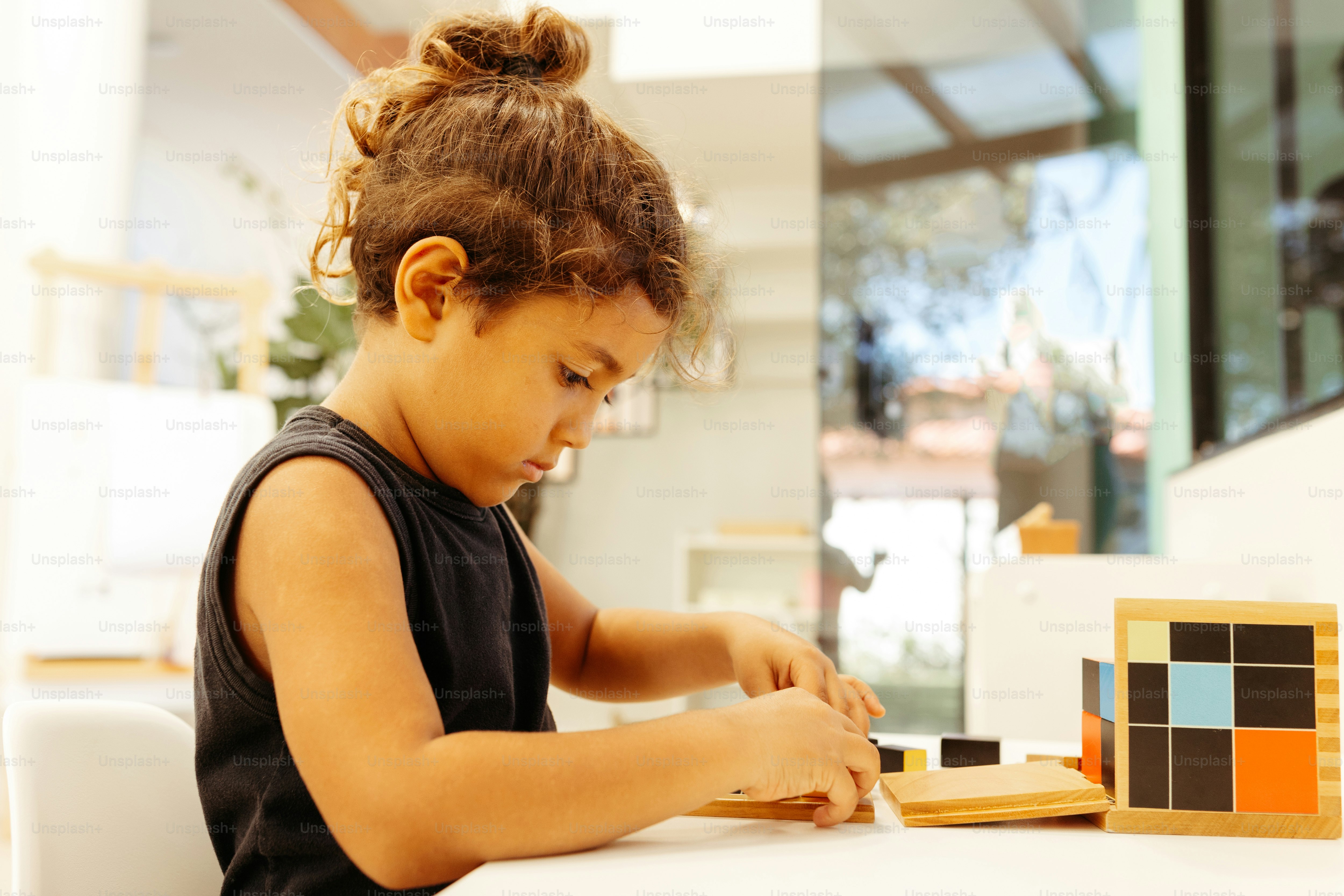 a little girl playing with a wooden block set