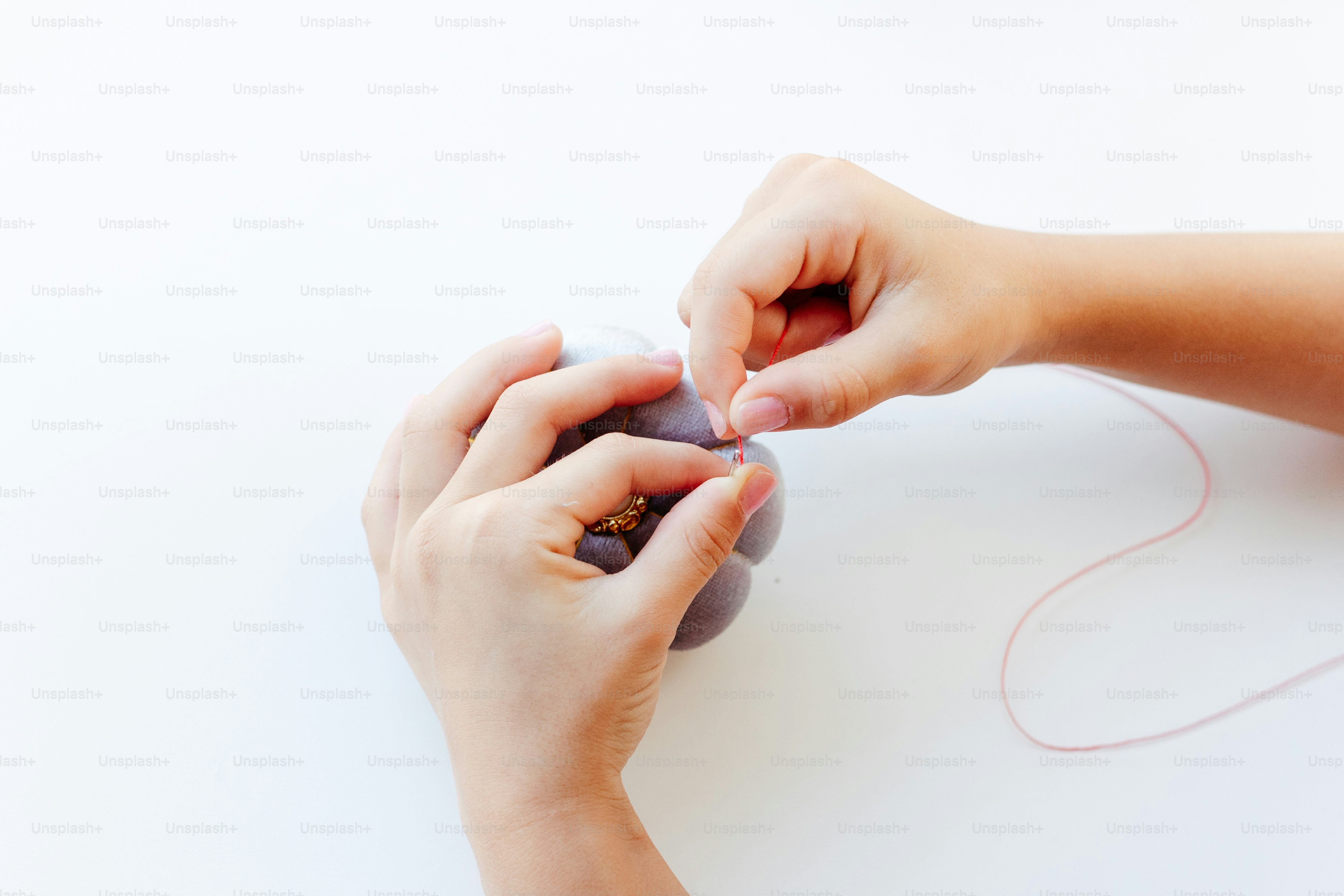 two hands are holding a ball of yarn