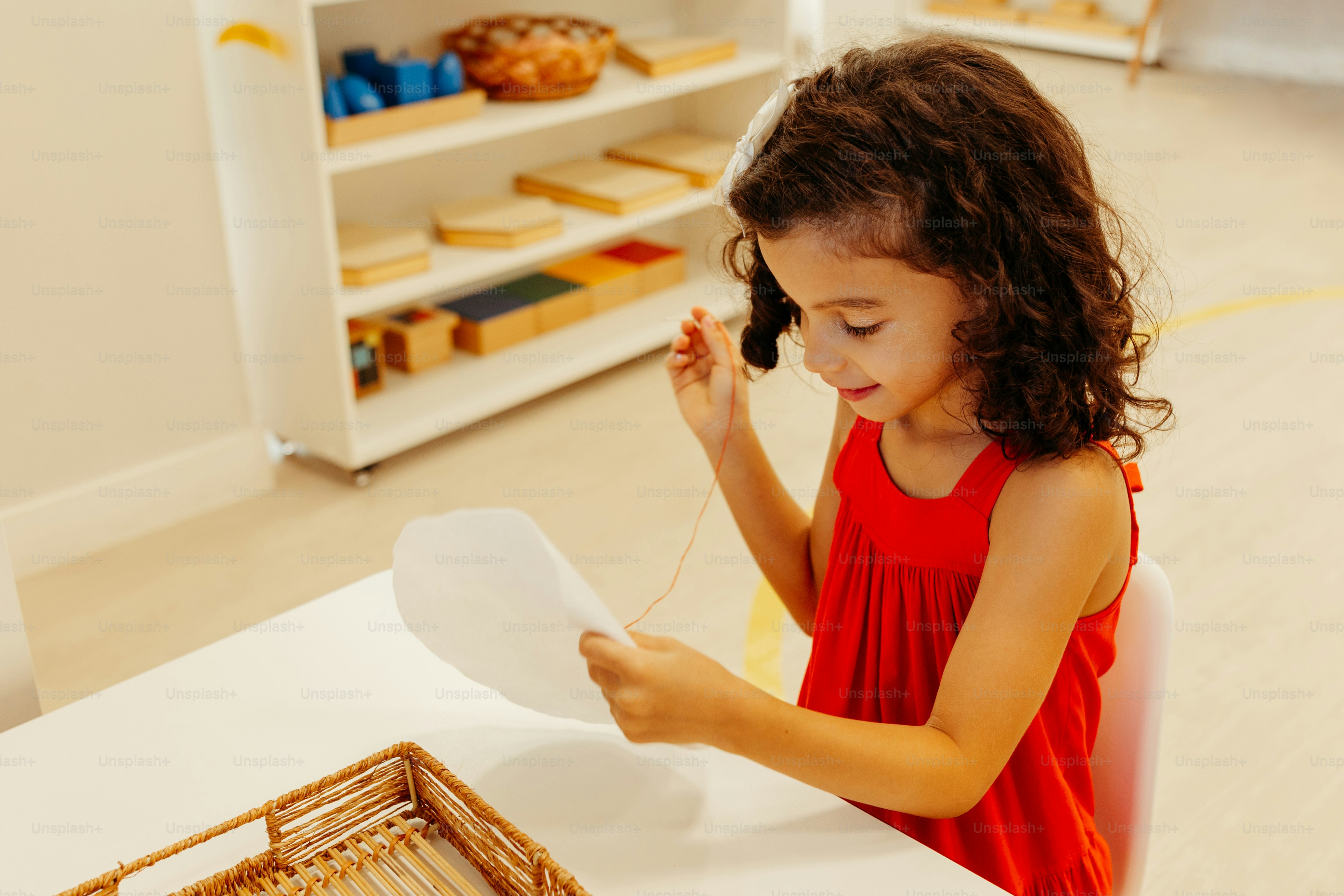 a little girl sitting at a table with a plate
