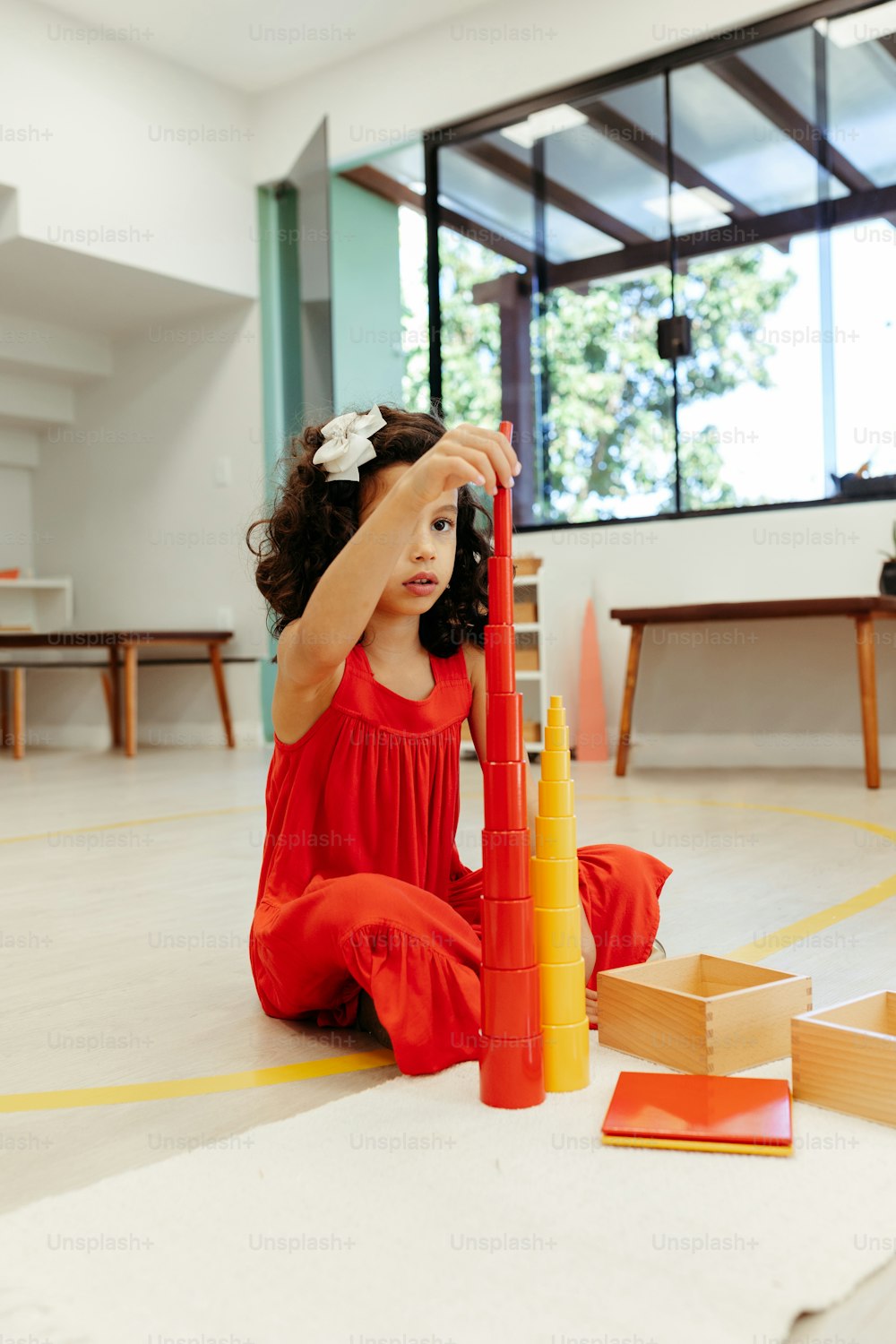 una bambina seduta sul pavimento che gioca con un set di edifici