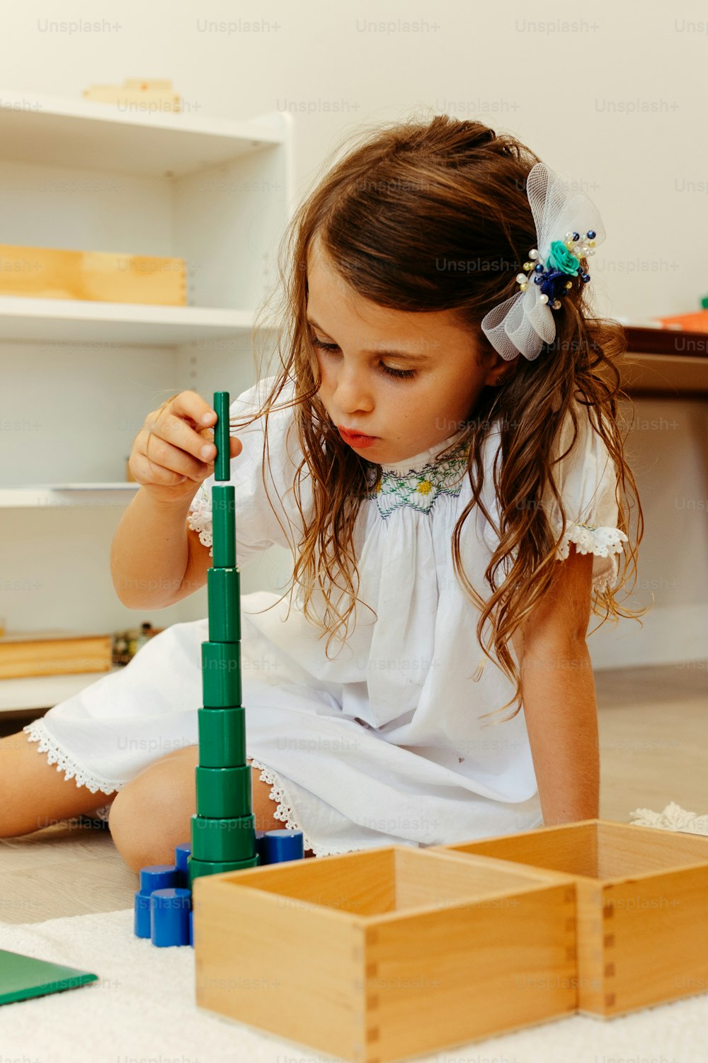 a little girl playing with a building set