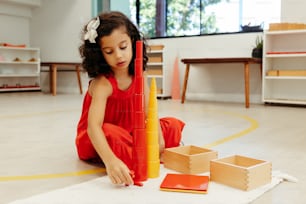 a little girl playing with a tower of blocks
