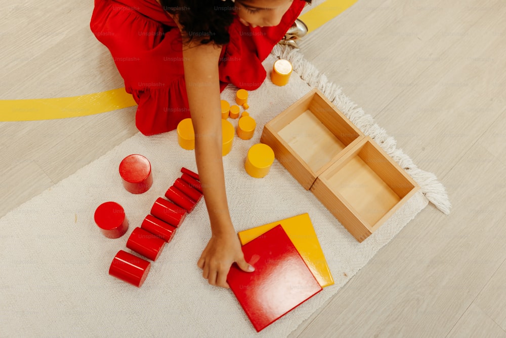 a woman in a red dress is playing with red and yellow objects