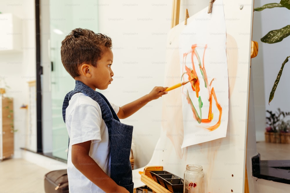 um menino pintando um quadro em uma tela