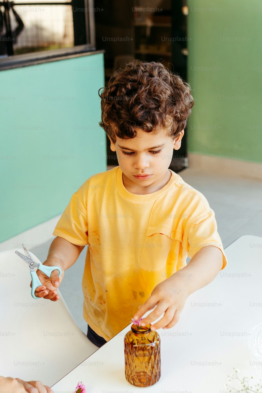 Ein kleiner Junge schneidet ein Stück Kuchen mit einer Schere