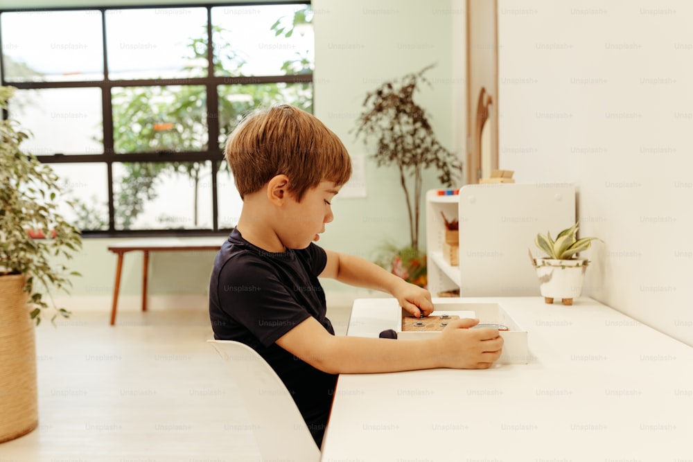 a young boy sitting at a white table