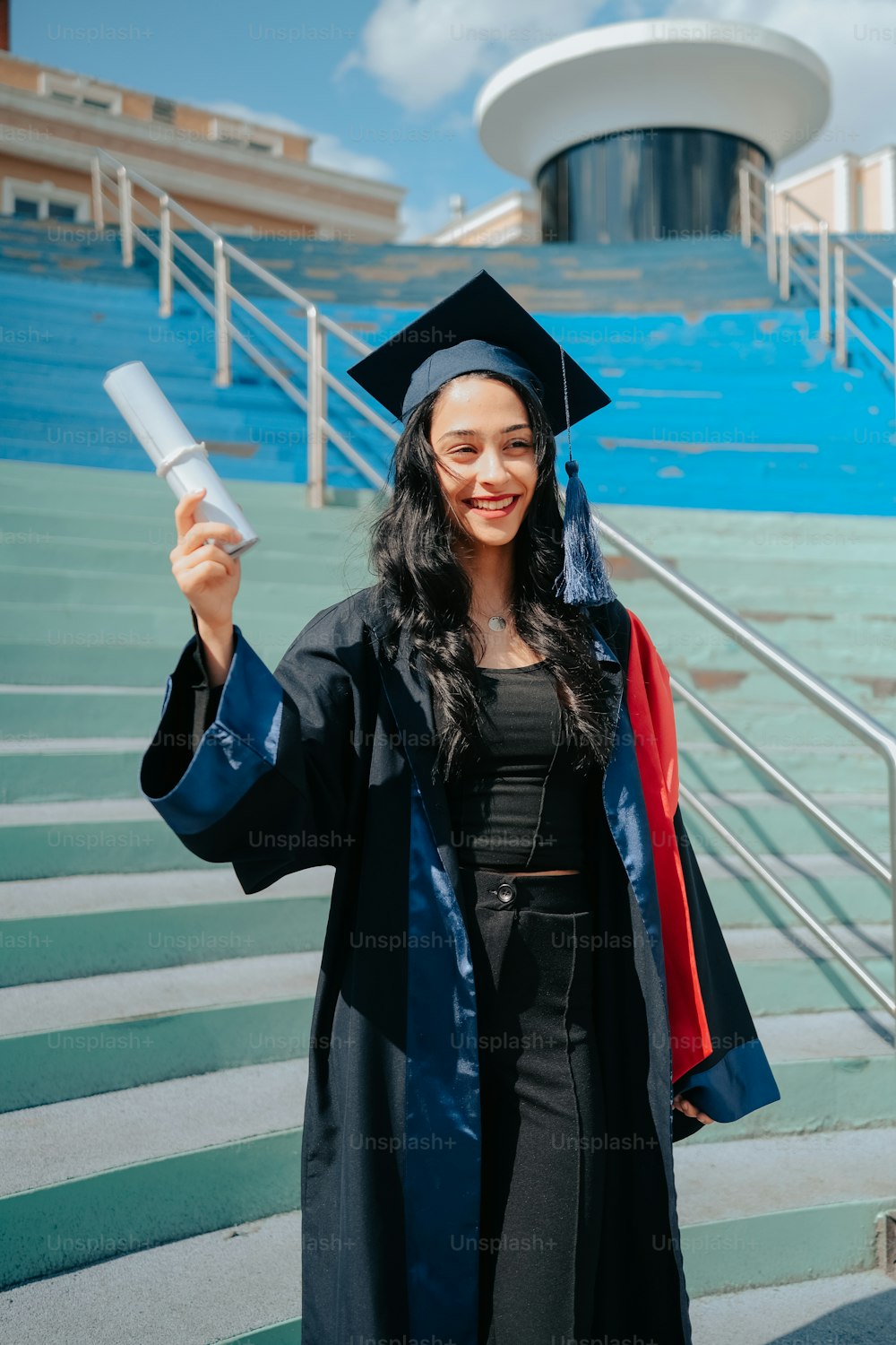 Una mujer con un vestido de graduación sosteniendo un diploma