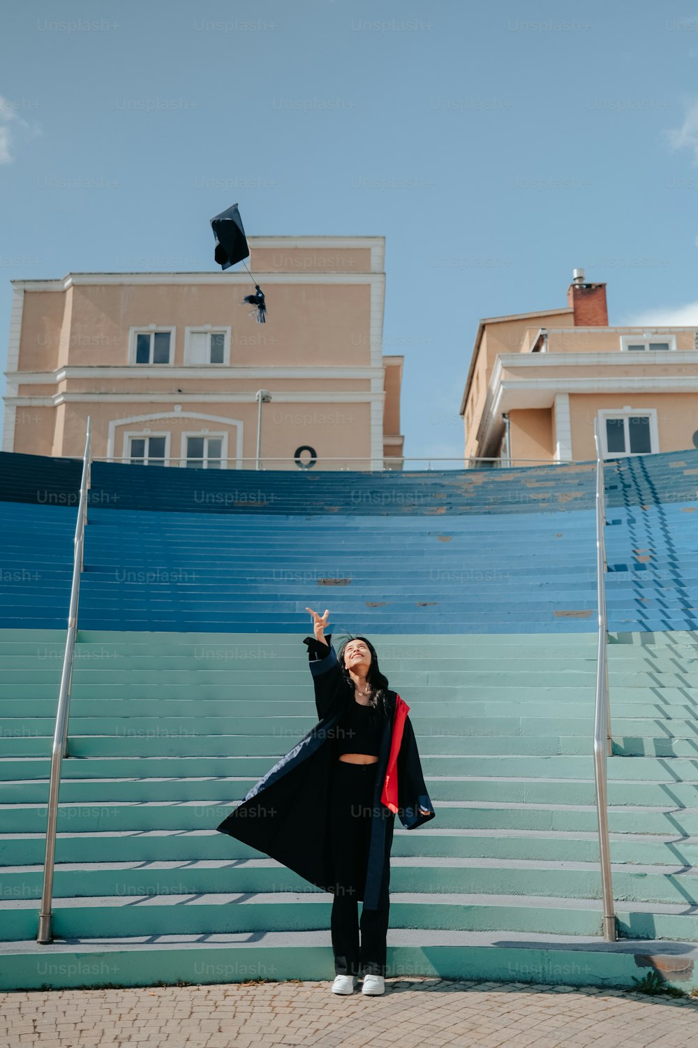 a woman in a graduation gown standing on a set of stairs