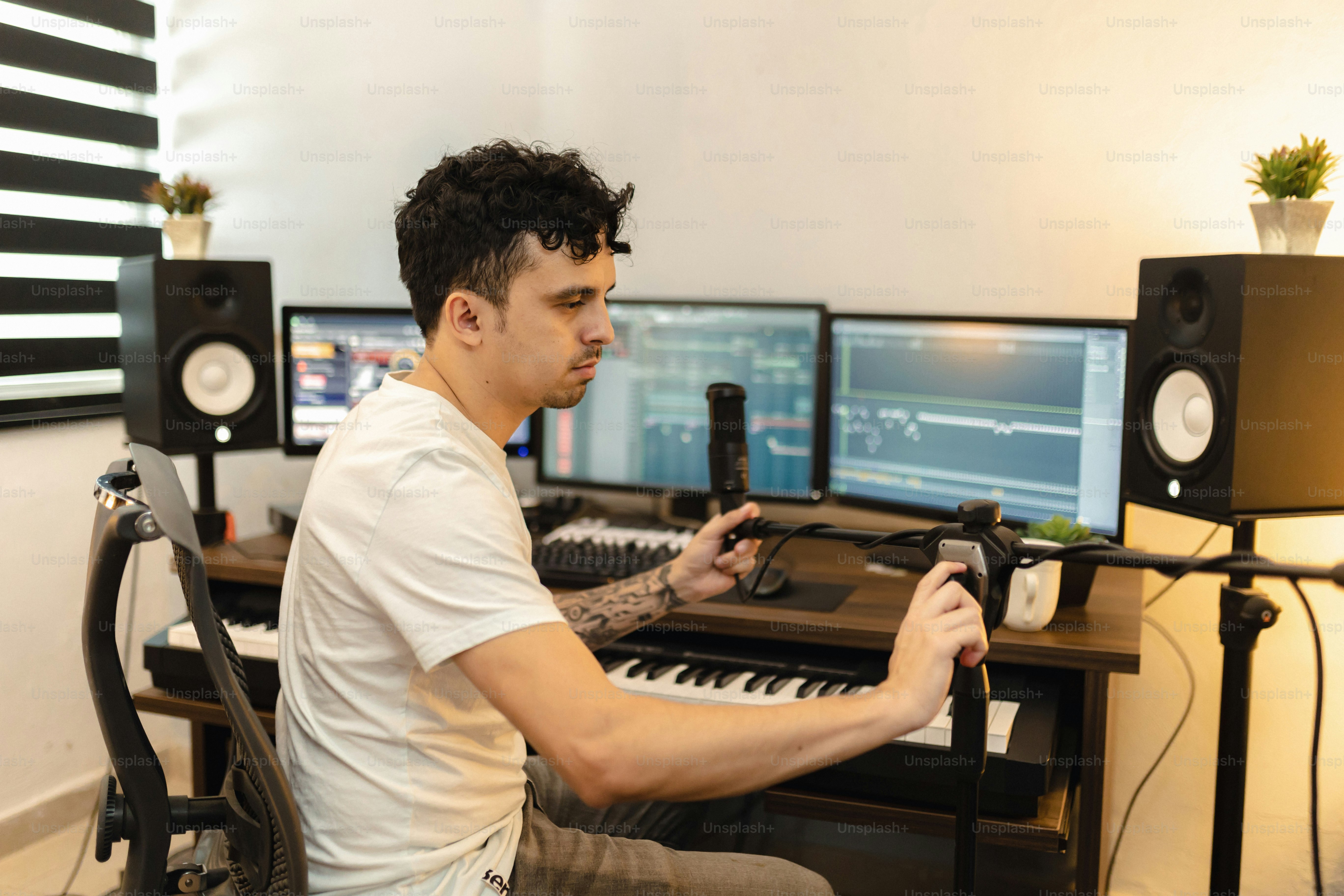 a man sitting in front of a computer with a microphone