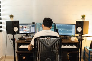 a man sitting at a desk in front of two computer monitors