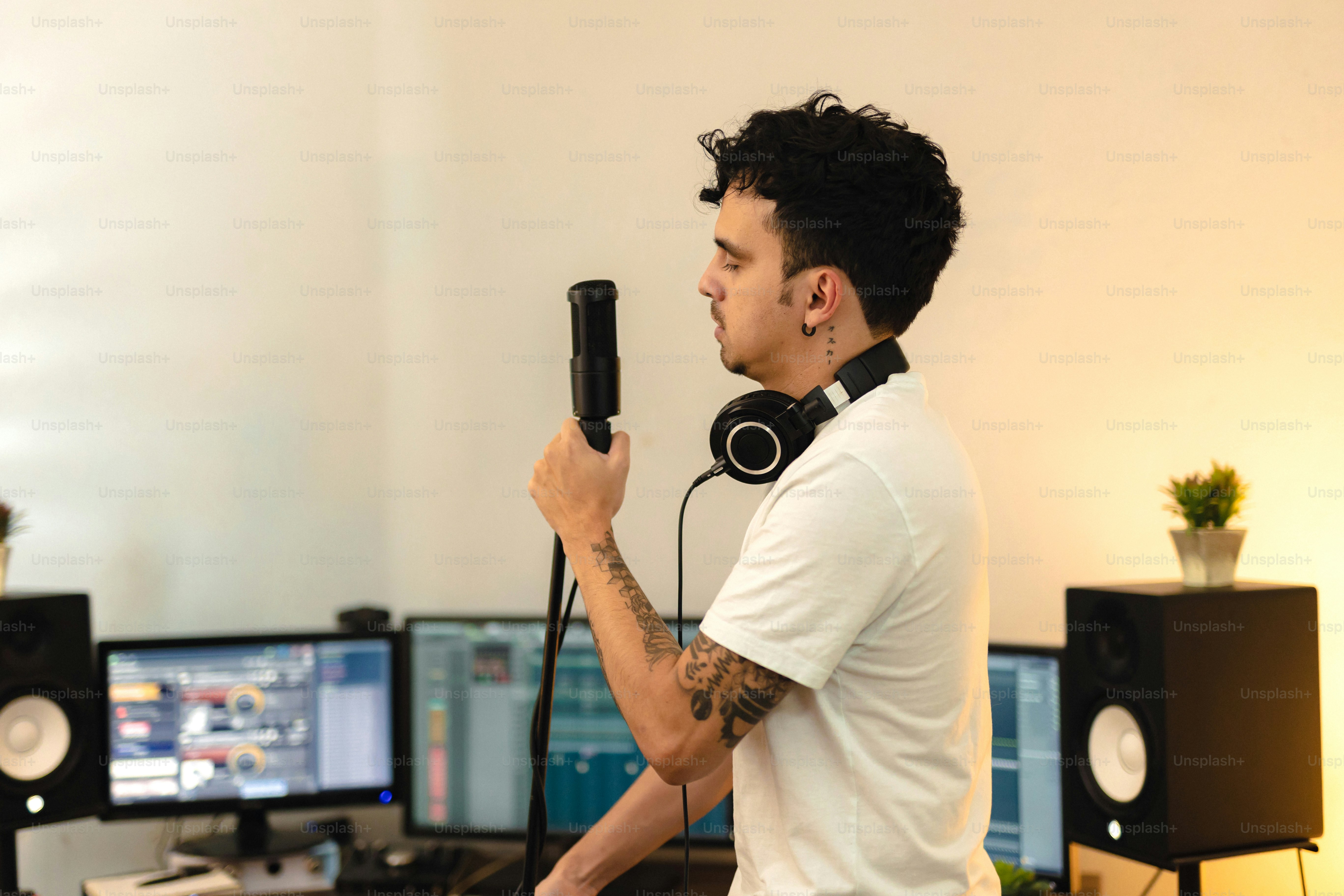 A man holding a microphone in front of a computer photo – Singer Image ...