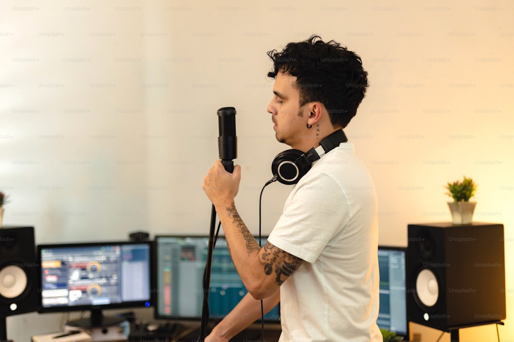 Un hombre sosteniendo un micrófono frente a una computadora