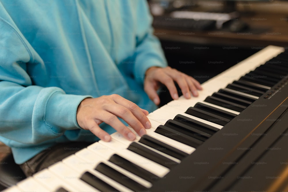 uma pessoa sentada em um piano com as mãos nas teclas