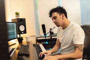 um homem sentado em um teclado na frente de um microfone