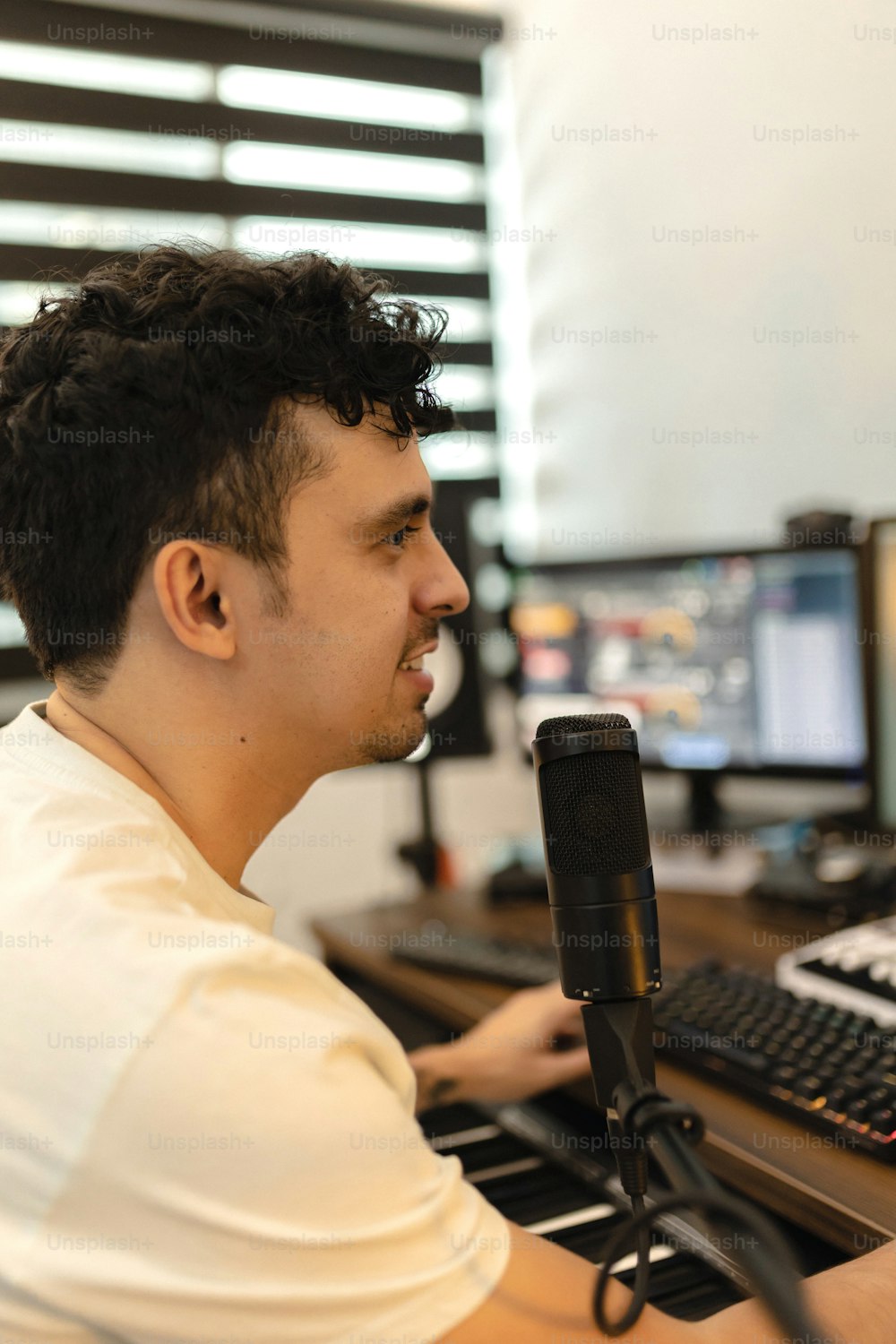 Un uomo seduto davanti a un computer con un microfono
