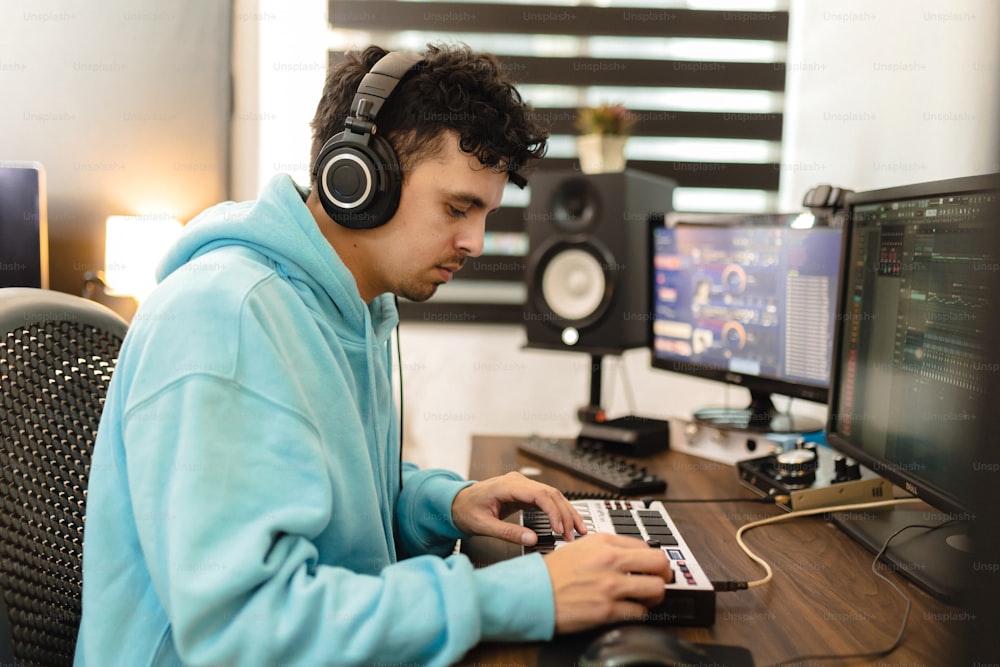 un joven con auriculares usando una computadora portátil