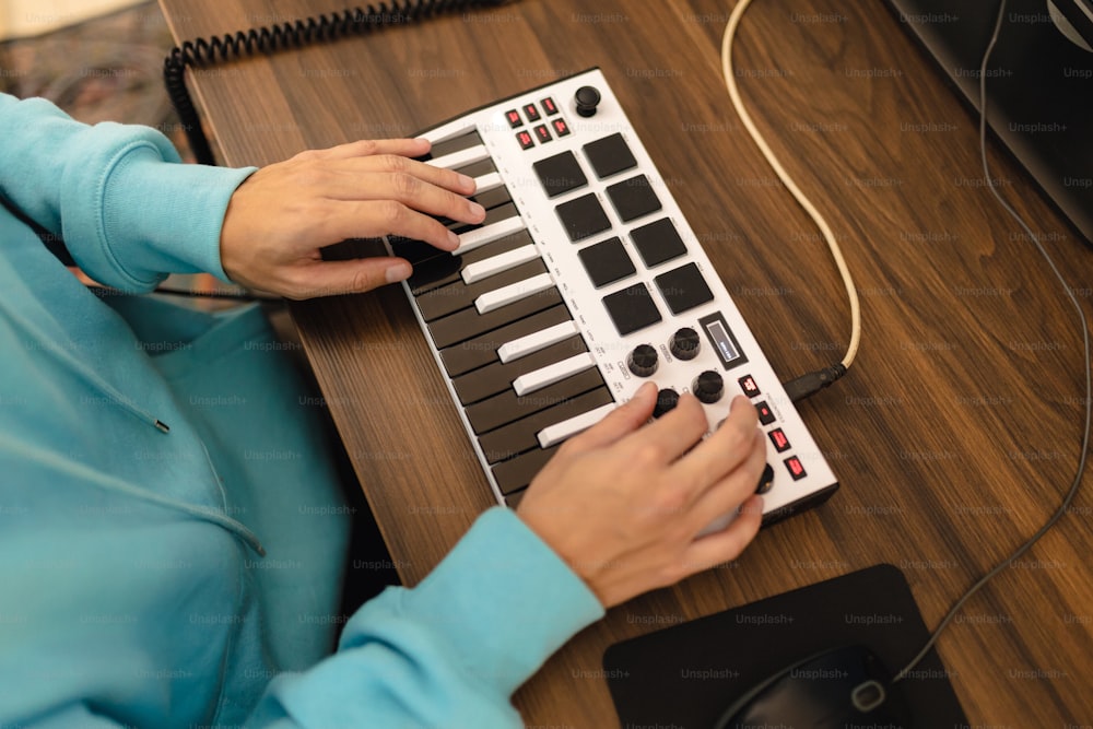 한 여자가 책상 위에서 전자 키보드를 연주하고 있다