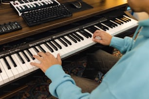uma pessoa sentada em um piano tocando um instrumento musical