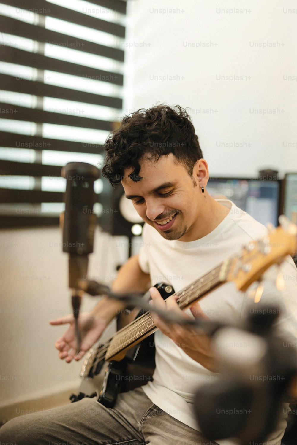 Un hombre tocando una guitarra en un estudio de grabación