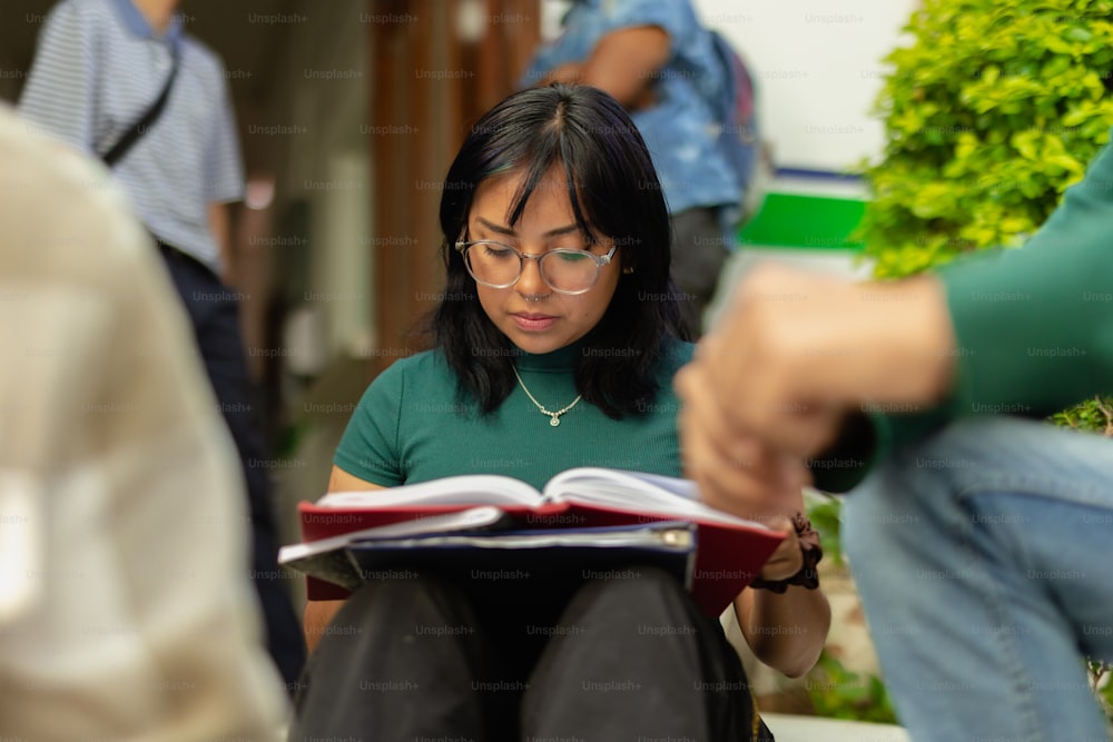 a woman sitting on the ground reading a book