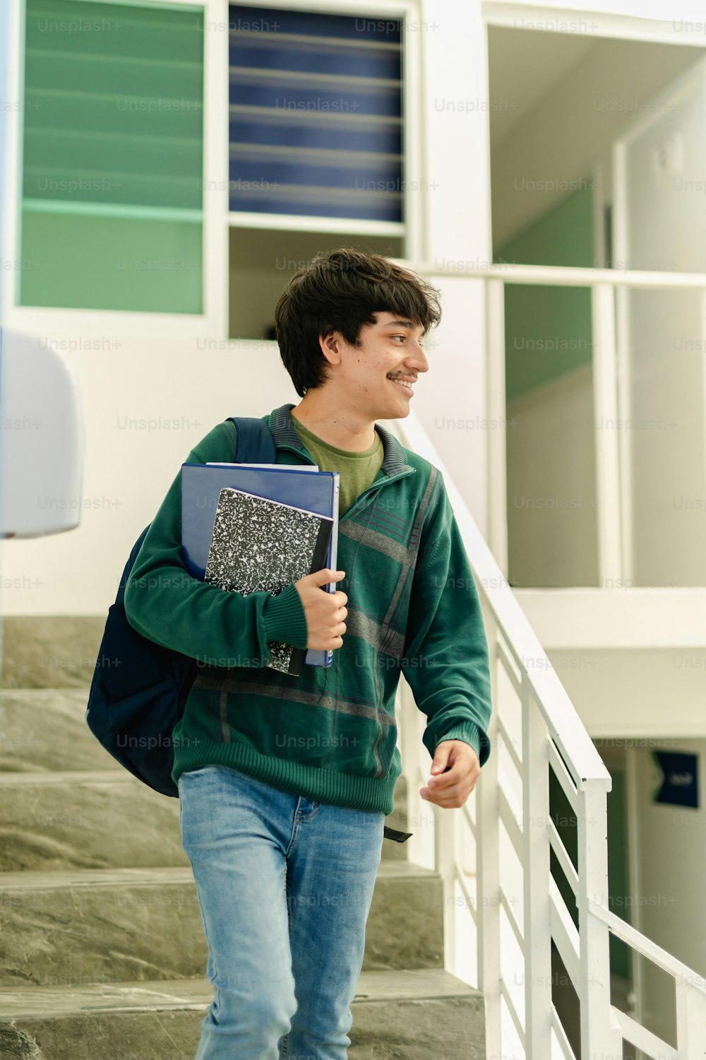 a man walking down a flight of stairs with a book in his hand