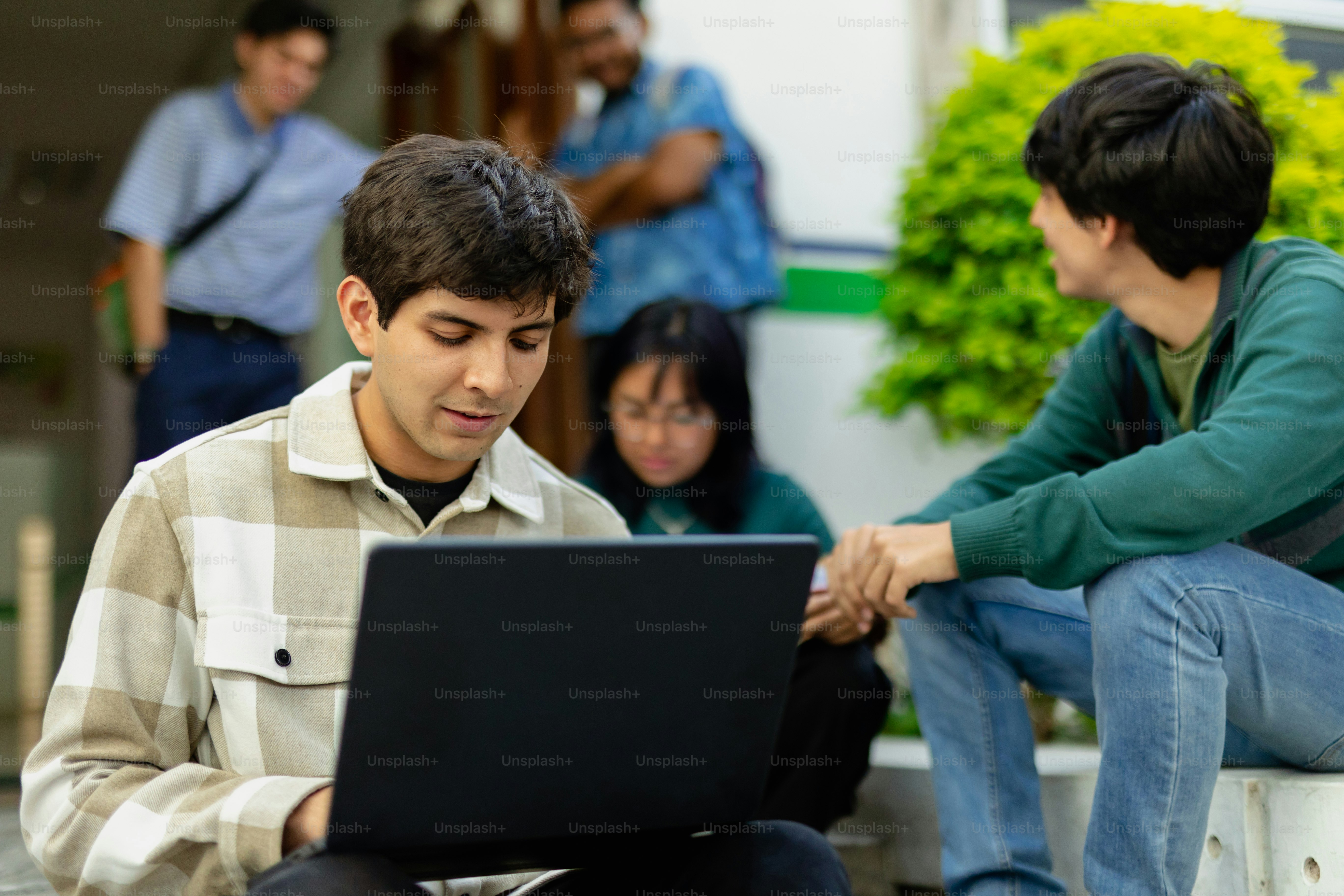 a man sitting on a bench using a laptop computer