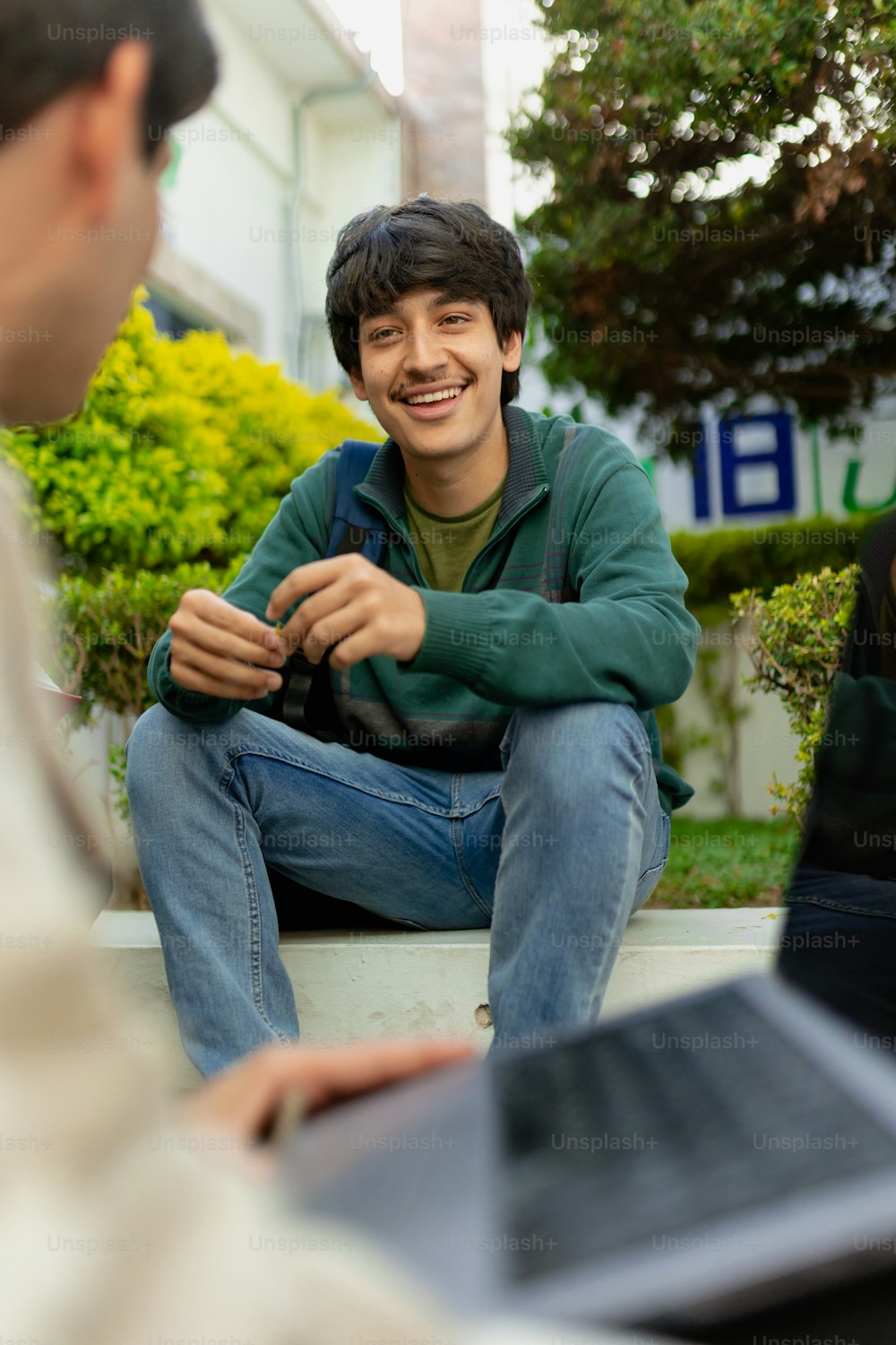 a man sitting on the ground with a laptop