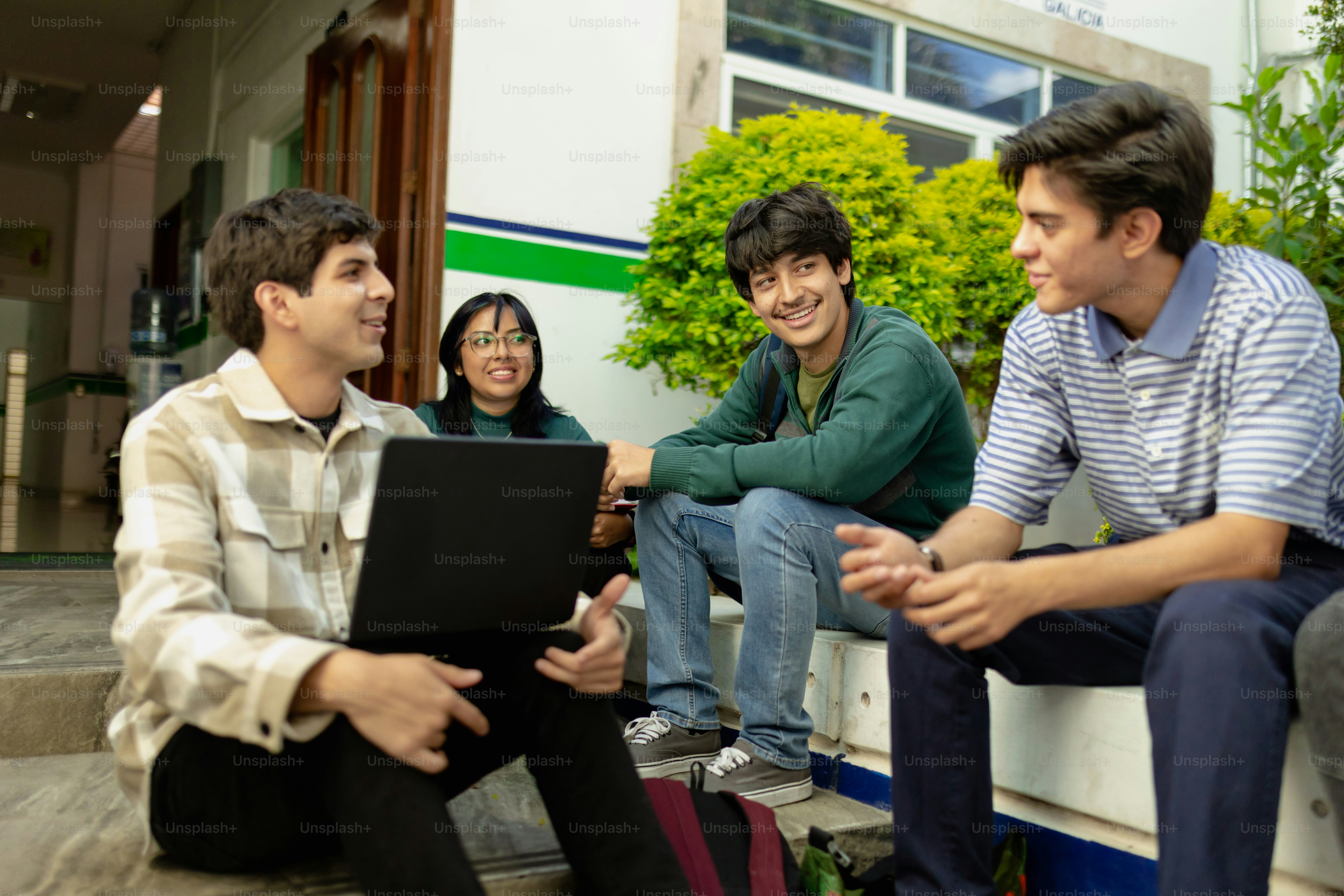 Eine Gruppe junger Leute, die auf den Stufen eines Gebäudes sitzen